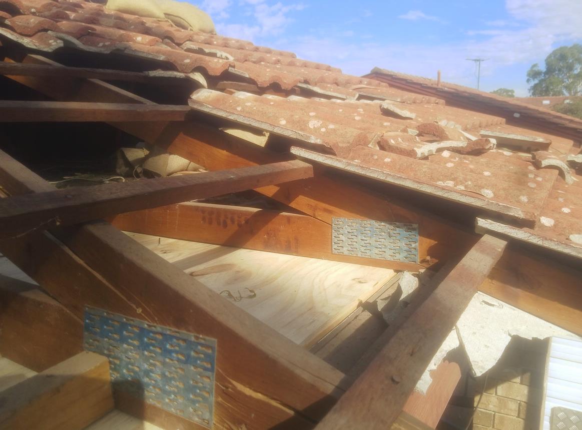 Damaged timber roof truss exposed during a structural inspection
